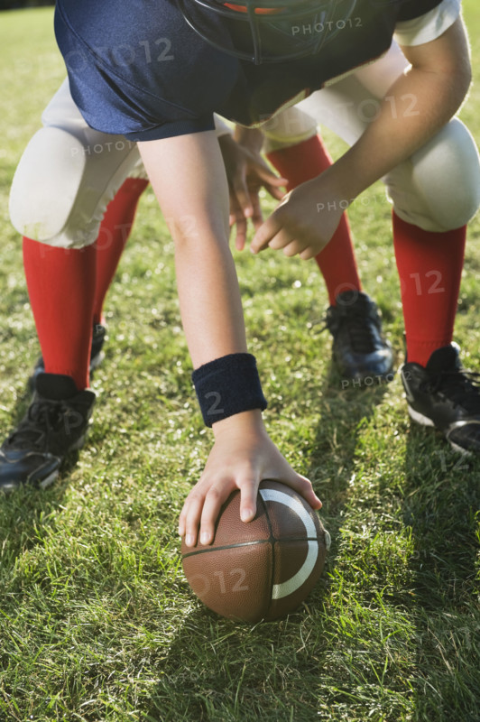 Football center preparing to snap football. Date: 2008