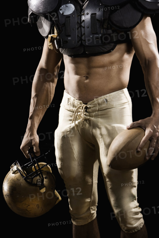 Football player with protective gear, football, and helmet. Date: 2008