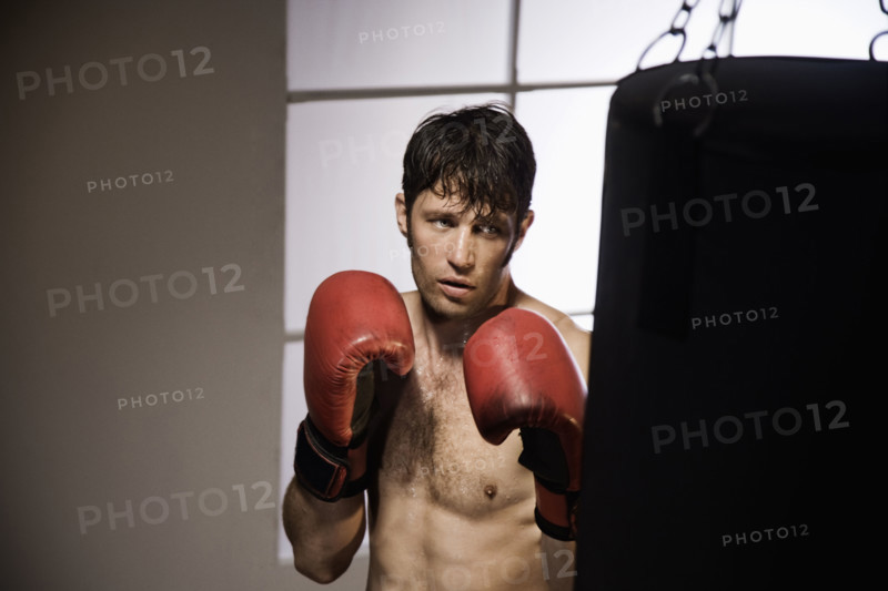 Boxer training with punching bag. Date : 2008