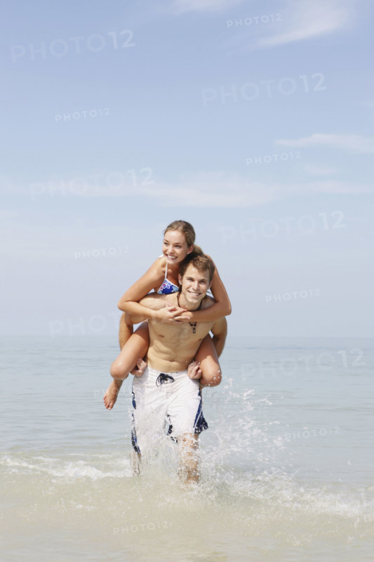 Couple splashing in ocean surf. Date: 2008