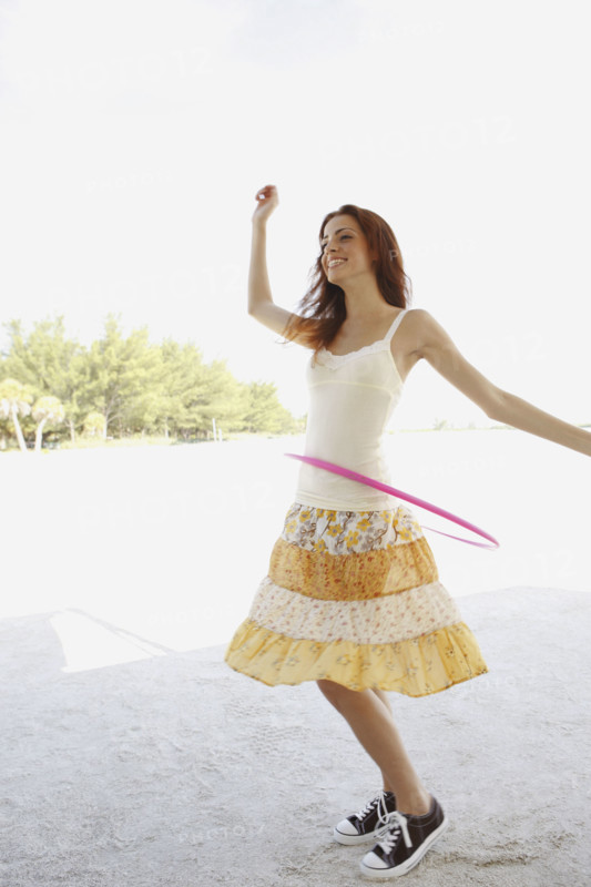 Woman on beach with hula hoop. Date: 2008
