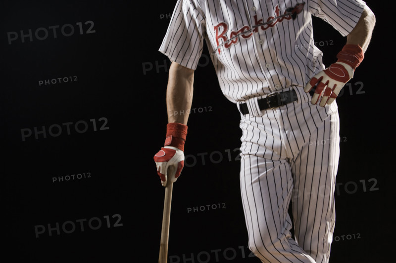 Midsection portrait of baseball player leaning on bat. Date : 2008