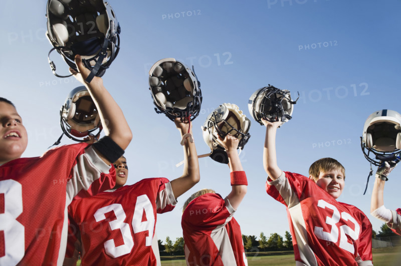 Football team holding helmets overhead. Date: 2008