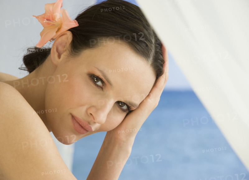 Close up of woman with flower in hair.