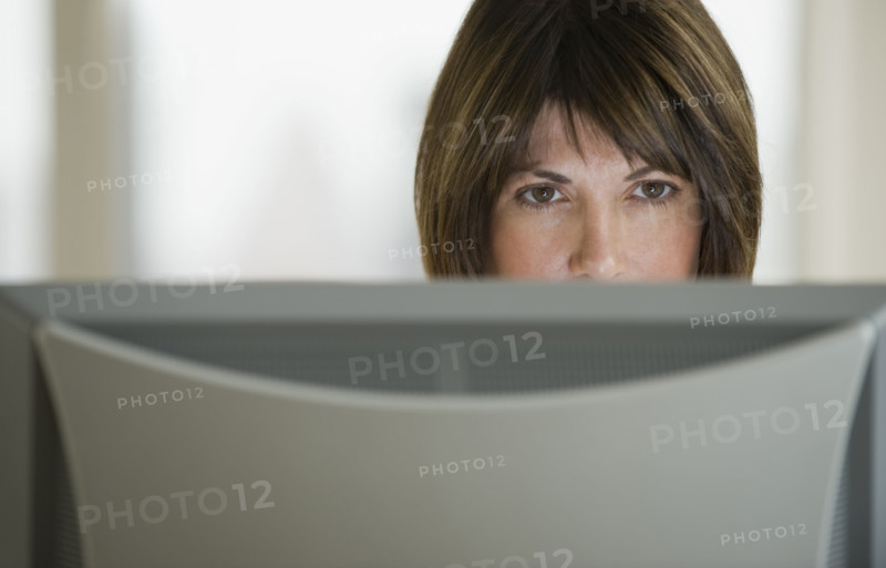 Close up of woman looking at computer monitor.