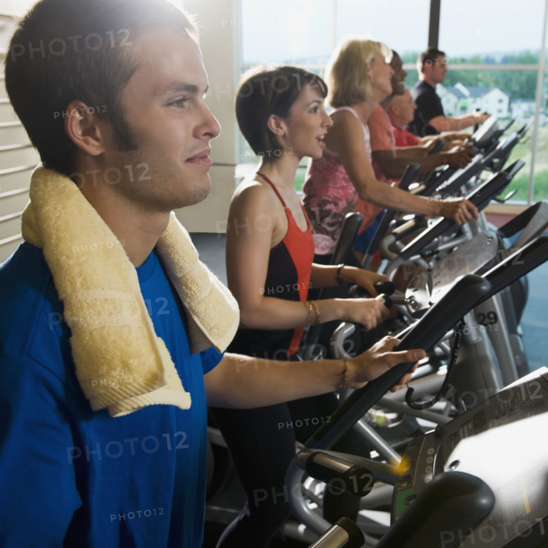 Men and women on elliptical trainers. Date : 2008