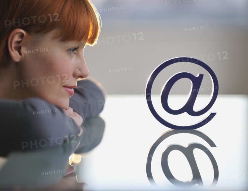 Woman looking at “at” symbol.