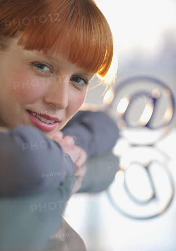 Woman looking at “at” symbol.