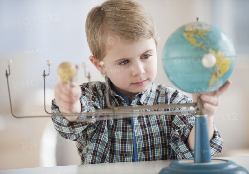 Boy looking at globe.