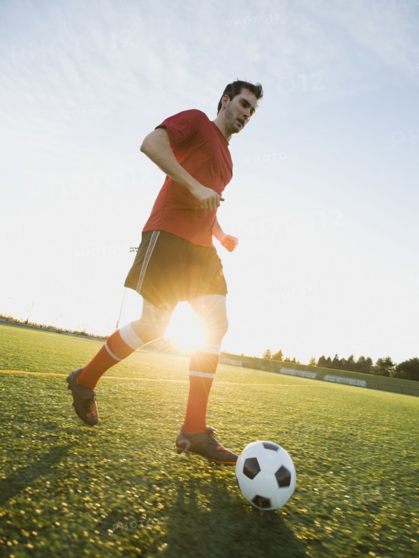 Soccer player dribbling ball.