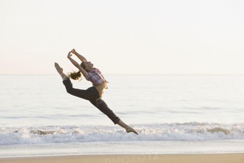 Woman dancing on beach. Photographe : PT Images