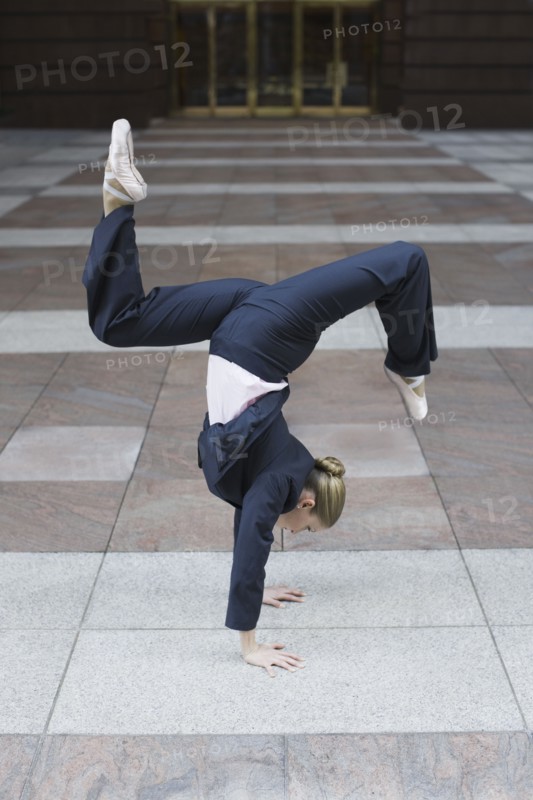 Businesswoman dancing in urban setting. Photographe : PT Images