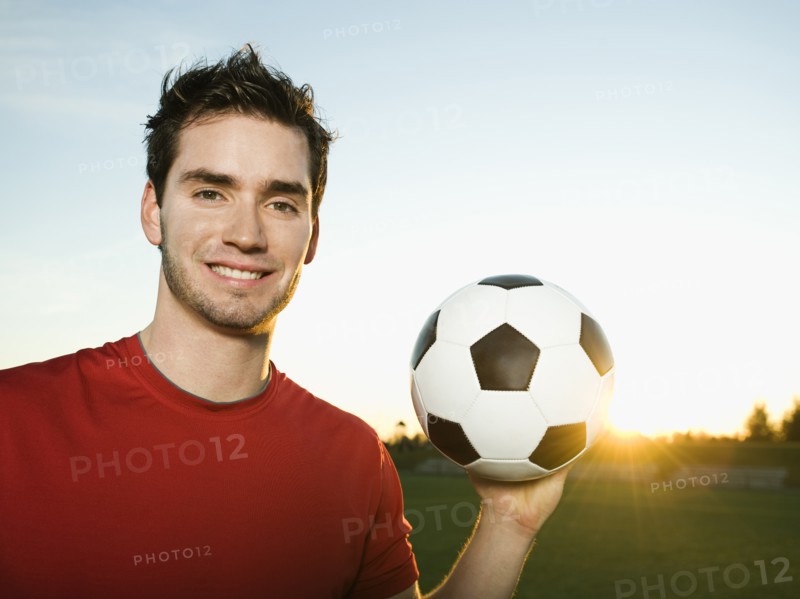 Soccer player holding ball.
