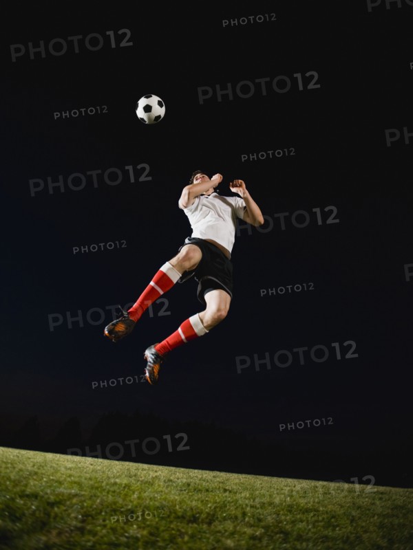 Soccer player heading ball.