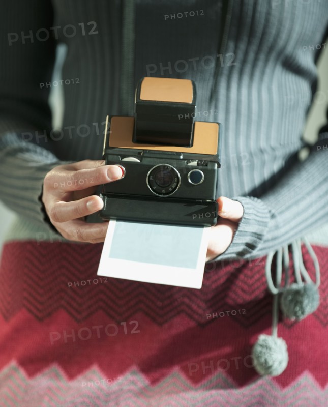 Woman holding vintage camera.