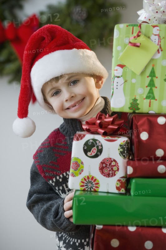 Boy posing with Christmas gifts.