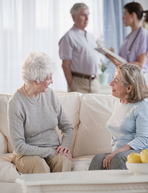 Senior woman talking on sofa.