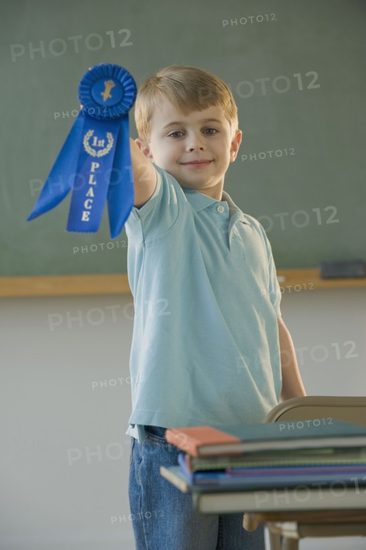 Boy holding first place ribbon.