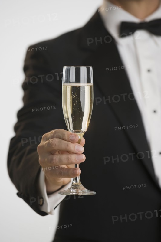 Man in tuxedo toasting with champagne.