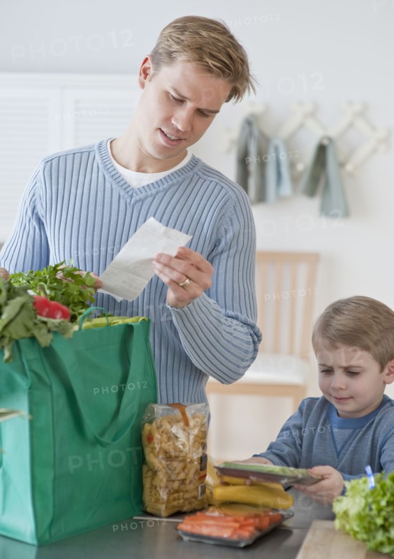 Father and son unpacking groceries.