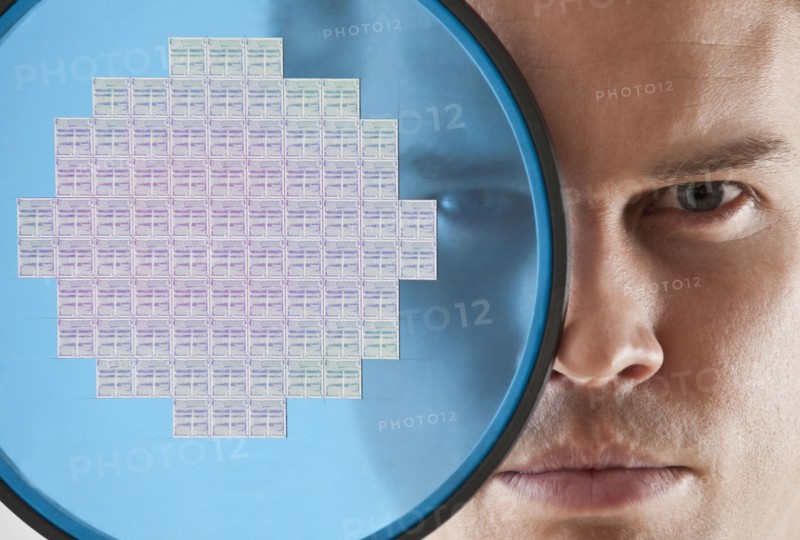 Close up of man looking through computer chip.