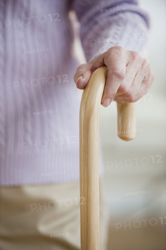 Close up of senior woman holding cane.