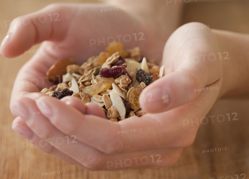 Woman dropping coins in piggy bank. Photographe : Jamie Grill