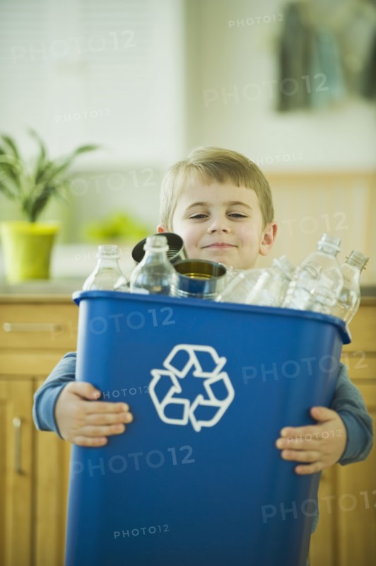 Boy carrying full recycling bin. Photographe : Daniel Grill