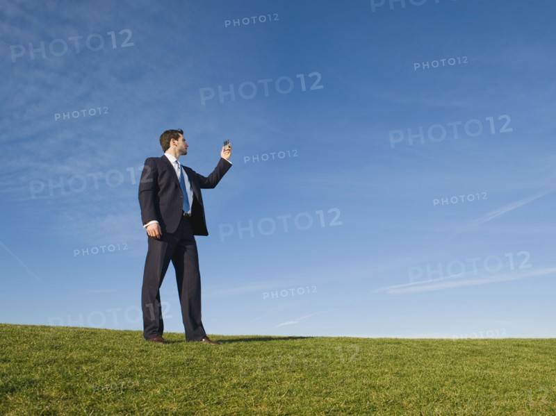 Businessman using cell phone outdoors.