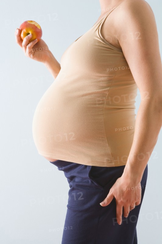 Pregnant woman eating apple. Photographe : Jennifer L. Boggs