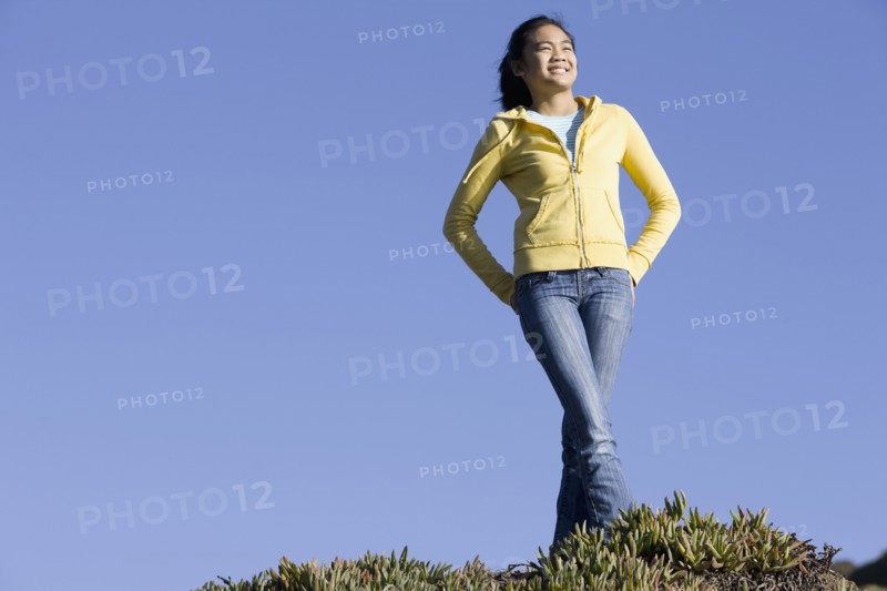 Teenage girl standing on hill. Photographe : PT Images