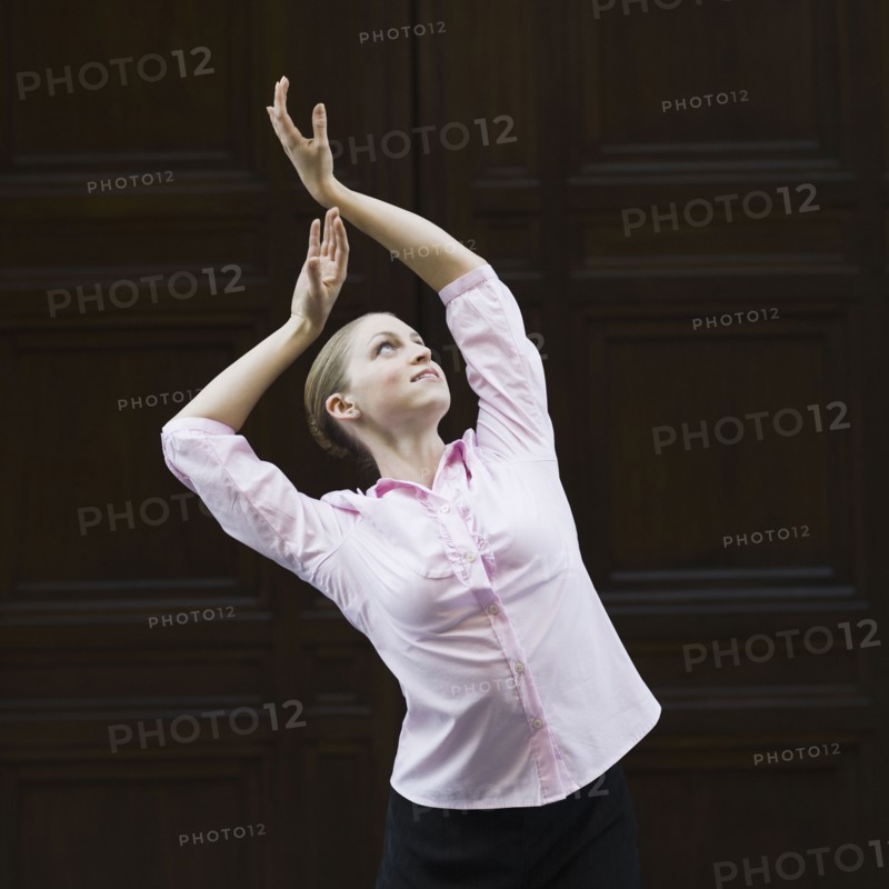 Businesswoman dancing in urban setting. Photographe : PT Images