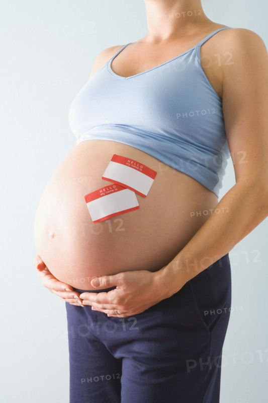 Pregnant woman with name tags on belly. Photographe : Jennifer L. Boggs