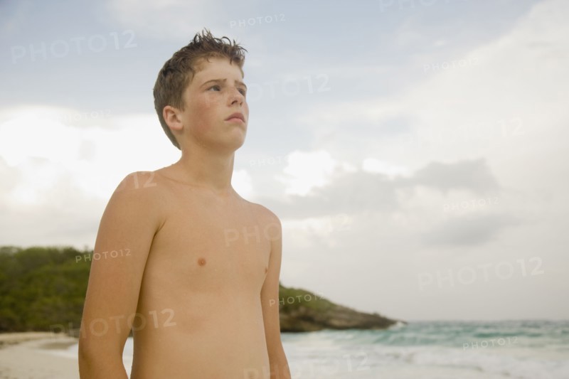 Boy standing on beach. Photographe : mark edward atkinson
