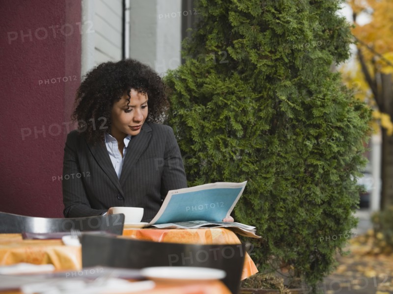 Businesswoman sitting at outdoor cafe.