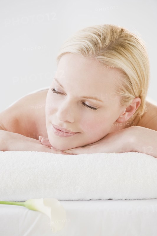 Woman relaxing on spa towel. Photographe : Daniel Grill