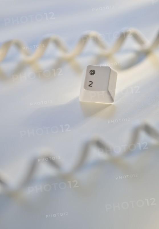Close up of telephone cord and computer key.