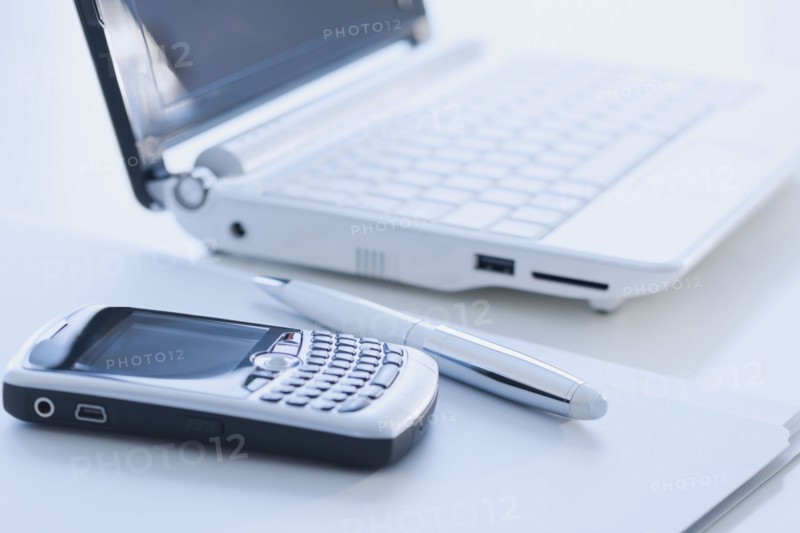 Cell phone and laptop on desk.