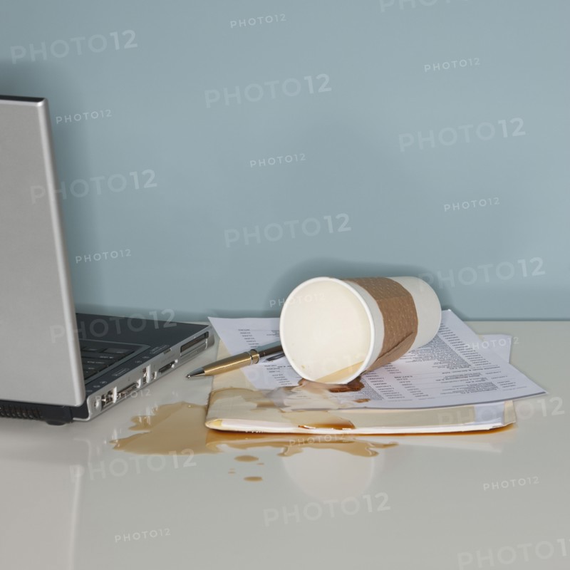Spilled coffee on office paperwork.