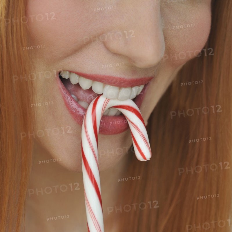 Woman biting candy cane.