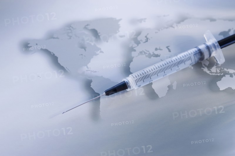 Syringe on world map.