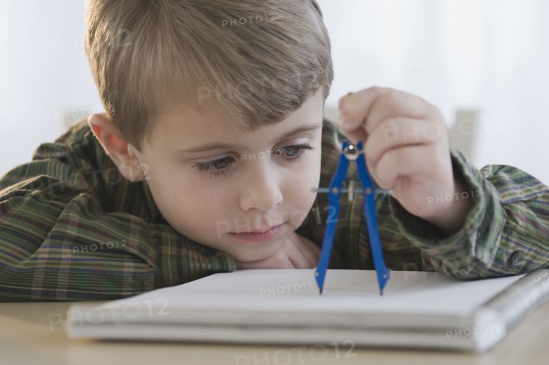 Boy using drawing compass.