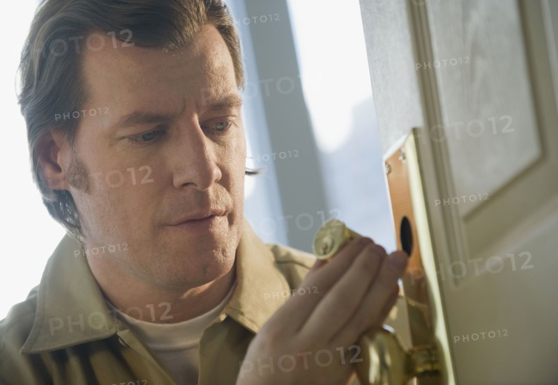 Locksmith repairing door lock.