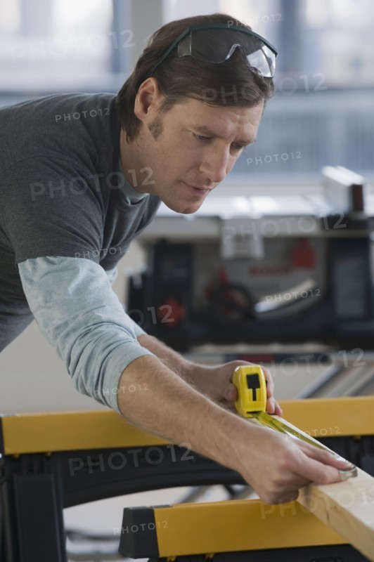 Construction worker measuring board.