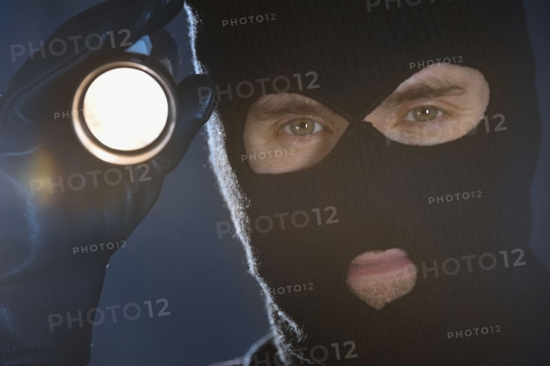 Burglar shining flashlight.