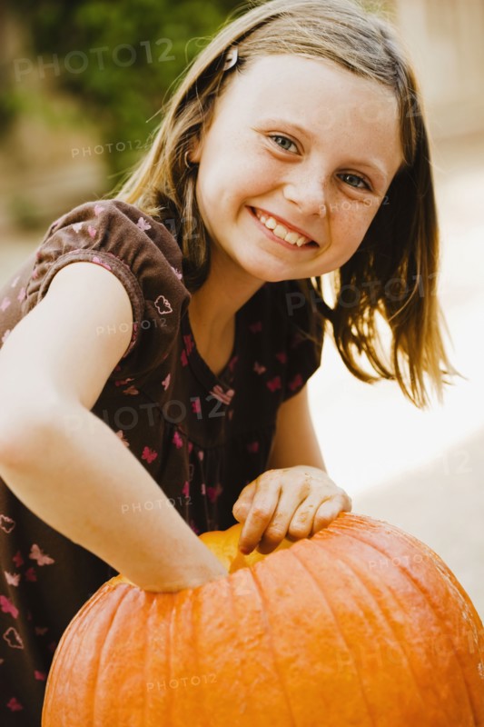 Girl scooping out pumpkin