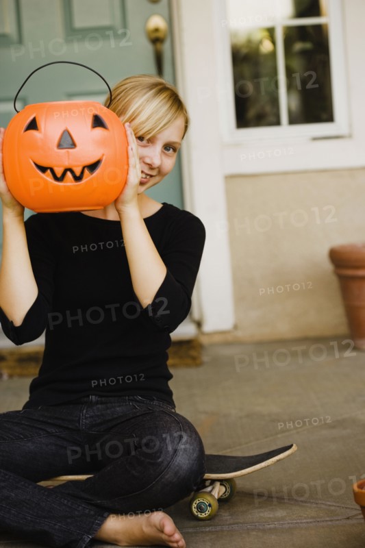 Girl holding platic jack-o-lantern