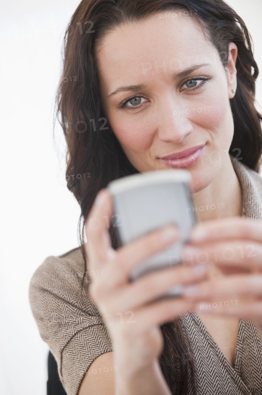 Woman using palmtop, smiling.