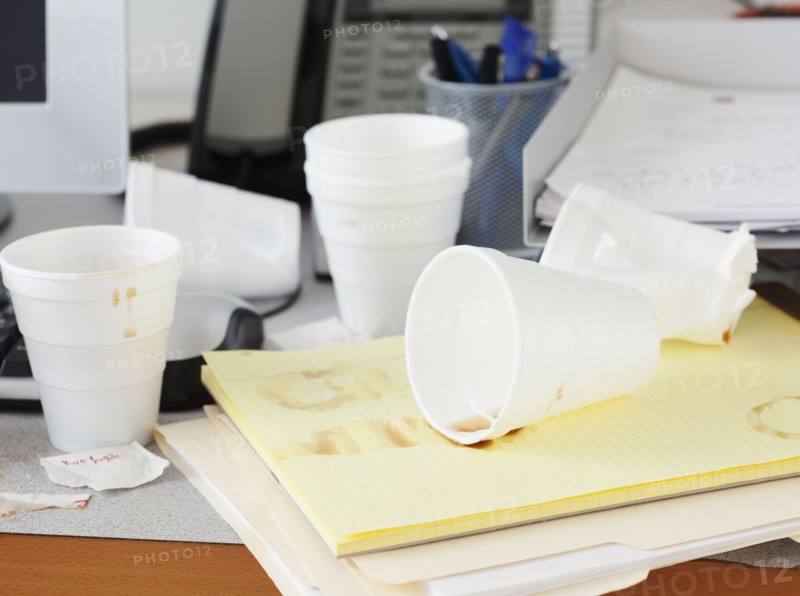 Messy office desk with empty disposable cups. Photographe : Jamie Grill
