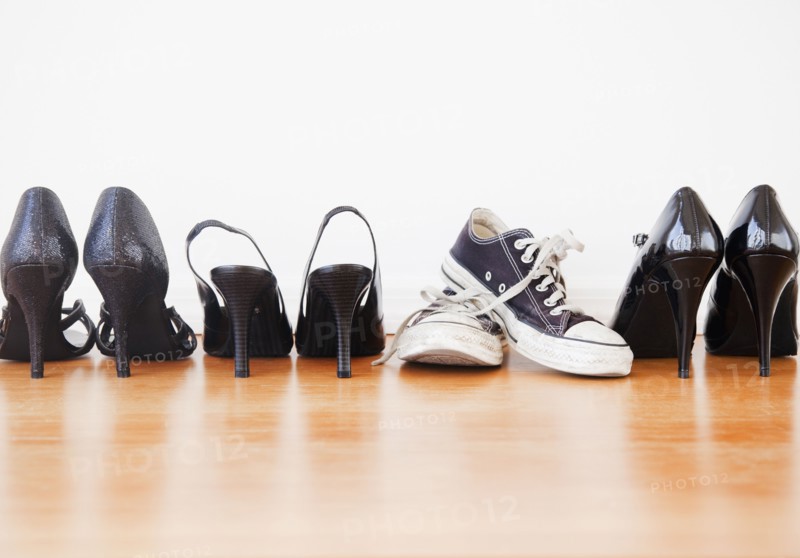 Canvas shoe in row of elegant high heel shoes. Photographe : Jamie Grill